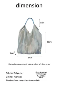 Detail view of floral embroidery bag with magnetic snap and two inner pockets