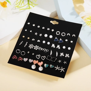 30 pairs of fashion stud earrings set with pearl, heart, and bow designs on card