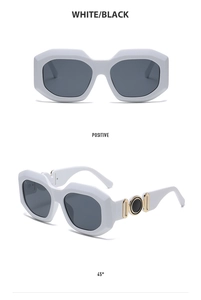 Detailed view of white retro sunglasses with bold gold and black ring temple accents