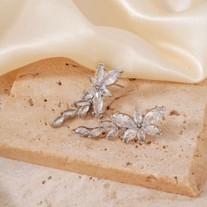 Macro view of flower stud earrings with marquise-cut zircons on a stone display