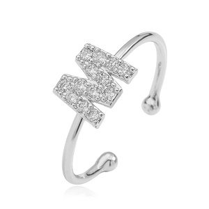 Macro shot of silver open ring with letter M design paved in sparkling zircon stones