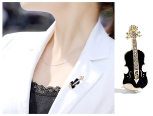 Detail of cello brooch with gold alloy base, black enamel finish and crystal inlay