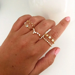 Detail of stacked gold S925 silver rings with zircon snowflakes and floral patterns