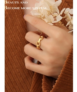 Close-up of a 18K gold plated titanium chain ring on model hand with autumn aesthetic