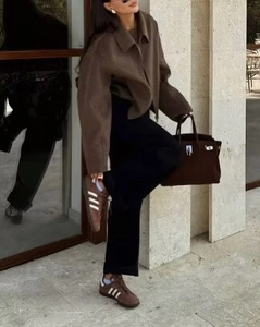 Photo street style d'une femme en veste marron à revers avec sac et baskets assortis