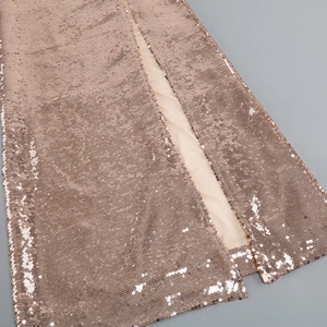 Detailed macro view of rose gold sequin fabric showing high-density stitching and side slit