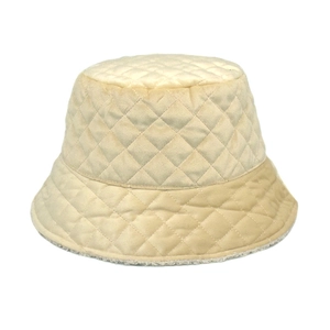 Detail of beige quilted bucket hat showing velvet texture and warm faux shearling lining