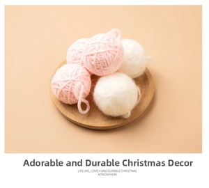 Pink and white wool ball Christmas ornaments with hangers on a wooden tray