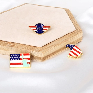 Detail of three USA patriotic enamel pins with eagle and flag designs on a display