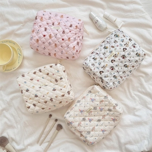 Detailed view of four quilted cotton pouches with cute animal prints and zipper closure