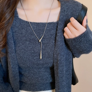Minimalist silver water drop pendant Y-shaped long necklace on dark sweater background