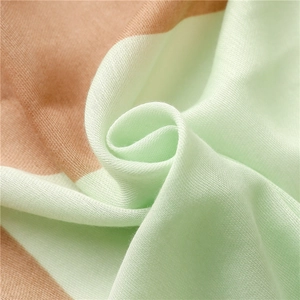 Close-up of mint green and peach cotton linen fabric with detailed soft knit texture