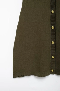 Detail of olive green knit dress showing golden button placket and textured fabric