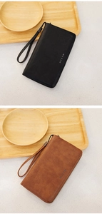 Detail of RFID long wallets in black and brown faux leather with wrist straps and logo