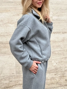 Detail of grey athletic tracksuit with standing collar zipper and soft cotton texture