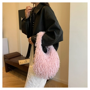 Pink plush faux fur hobo bag with fringe details shown on model with black leather jacket