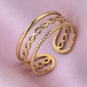 Detail of gold triple-layered ring featuring smooth, twisted, and hollow chain bands