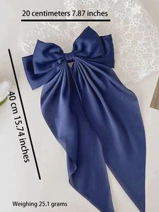 Detail of blue satin bow hair clip with measurement markings 20cm width and 40cm length