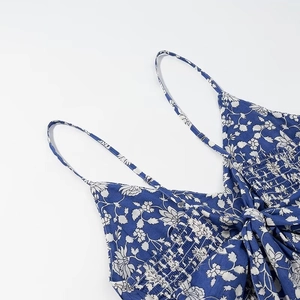 Detail of blue floral print dress featuring smocked elastic bodice and thin straps