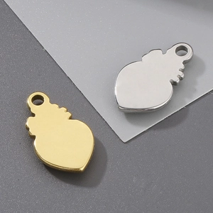 Detail of stainless steel heart pendants in gold and silver finish with textured edges
