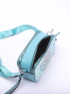 Detail view of sky blue crossbody bag featuring white mandala pattern and dual zipper closure