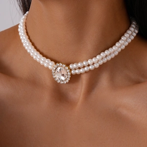 Close-up of double-layer pearl necklace with oval faux diamond and gold metal setting