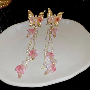 Élégantes boucles d'oreilles papillon dorées avec pétales roses et perles blanches
