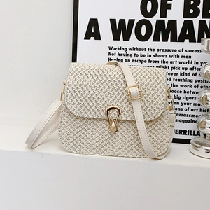 Minimalist cream woven crossbody bag with golden teardrop clasp and adjustable strap