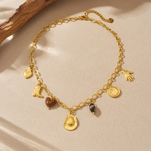 Gold-plated western charm necklace with cowboy boot, hat and moon pendants on beige stone