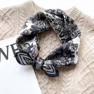Artistic silk scarf with black and white tree landscape print on a beige knitted sweater