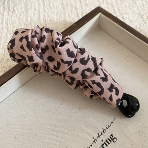 Detail of pink leopard print fabric banana clip on a white fabric display tray