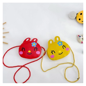 Detail of cute rabbit shoulder bags for girls in red and yellow with braided straps