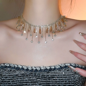 Close-up of luxury gold fringe necklace with amber crystals on model neck