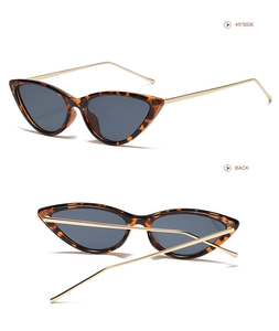 Detail shot of tortoise shell cat-eye sunglasses with slim gold metal temples and gray lenses
