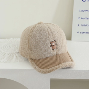 Close-up of cozy teddy fleece texture and bear embroidery on the beige baseball cap