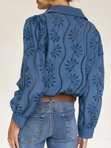 Detail view of blue long sleeve blouse featuring intricate hollow floral embroidery on back