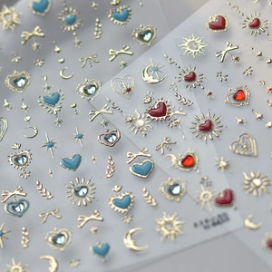 Macro shot of gold star and moon nail stickers with blue gems on transparent backing
