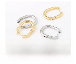 Close-up of gold and silver stainless steel U-shaped oval earrings with vacuum plating