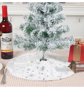 Detailed view of white faux fur Christmas tree skirt with silver sequin snowflakes décor