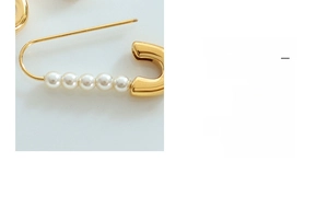 Macro shot of 18K gold plated safety pin earrings with five white pearls detail