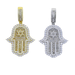 Dettaglio dei ciondoli a mano di Hamsa in oro e argento con strass e stella esagonale