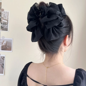 Elegant large black mesh bow claw clip for women's hair styling on model's head