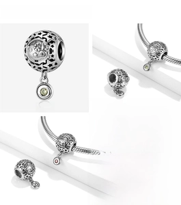 Macro detail of S925 sterling silver zodiac charms with colorful crystal pendants