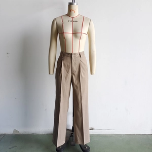 Detail view of khaki high-waisted wide-leg trousers with front pleats on a mannequin