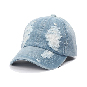 Close-up of light blue washed denim baseball cap featuring distressed ripped details
