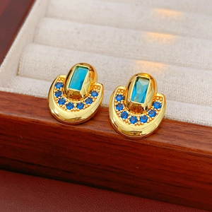 Détail de boucles d'oreilles vintage dorées avec pierres bleues dans leur écrin