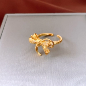 Macro view of 18K gold plated bow ring featuring delicate pavé crystals and open band