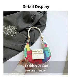 Detail of multi-color geometric patchwork handbag with gold metal buckle and white handle