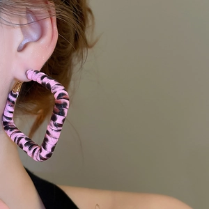Gros plan d'une créole carrée rose à motif léopard portée par un mannequin, style rétro