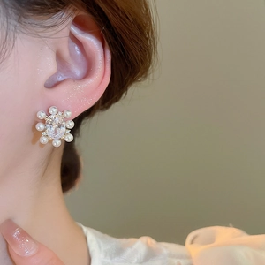 Detail showing a 14k gold plated flower earring with zircon center and white pearls